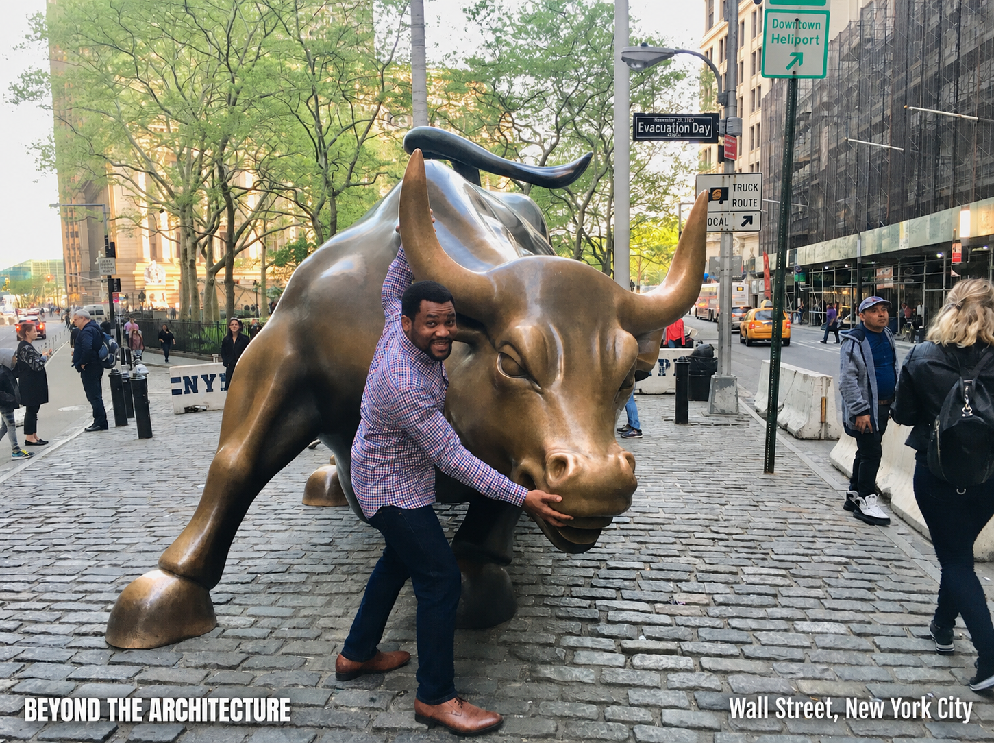 Osasere Ehigie holding the Charging Bull sculpture by its horn in New York City